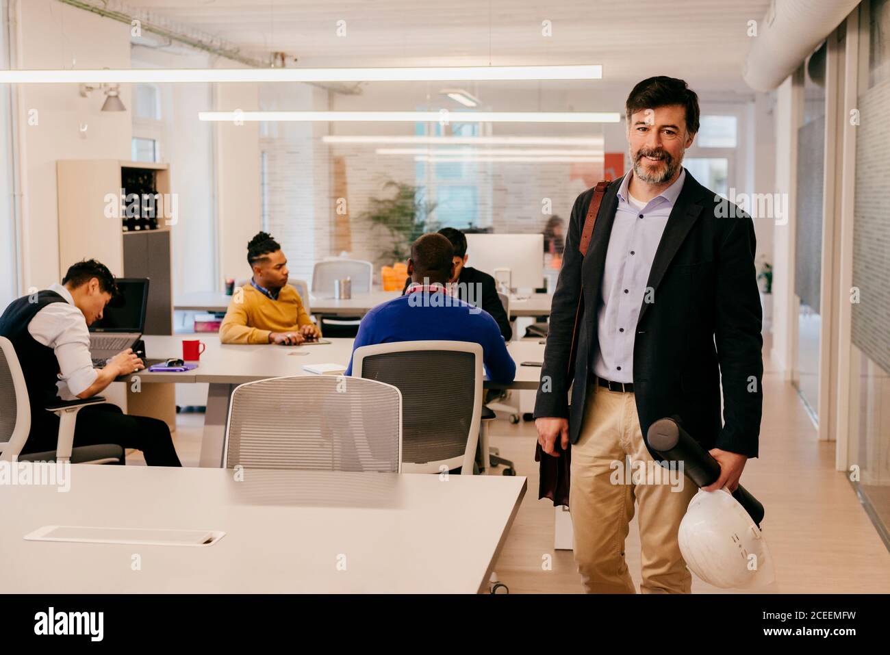 Beau homme adulte debout sur une table au bureau Banque D'Images