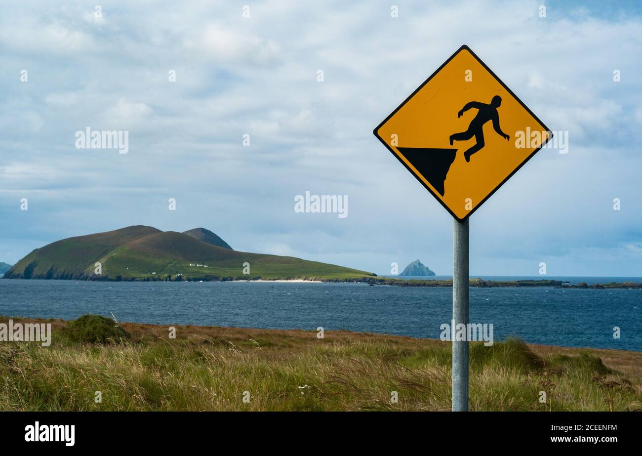 Panneau d'avertissement descendant au bord de la falaise au-dessus de la baie de Dunquin sur la péninsule de Dingle, côte ouest du comté de Kerry, Irlande Banque D'Images