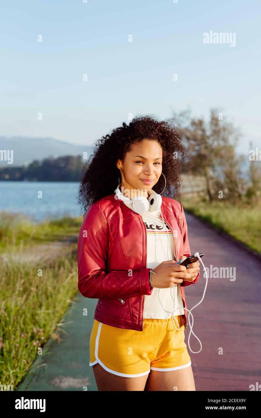 Femme afro-américaine avec smartphone à la campagne Banque D'Images