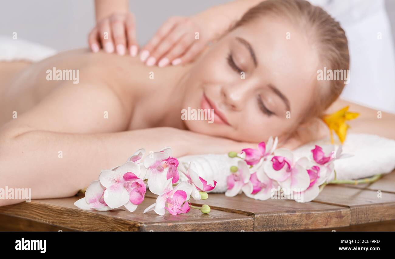 Plaisir des soins spa. Les mains des femmes font un massage relaxant pour une femme avec les yeux fermés Banque D'Images