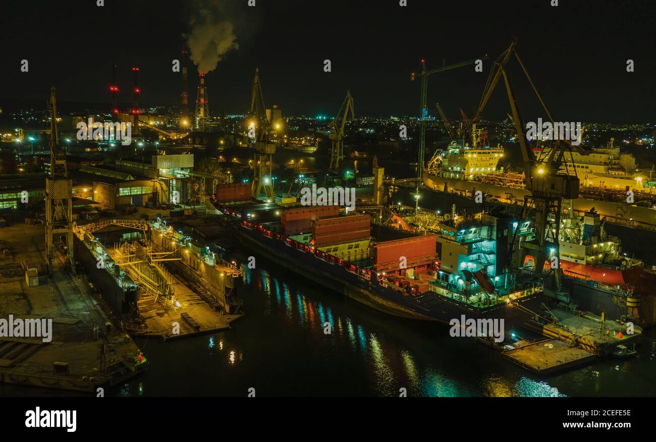 Panorama aérien nocturne du chantier naval de Gdansk avec des navires et des sous-marins dans les quais flottants secs. Banque D'Images