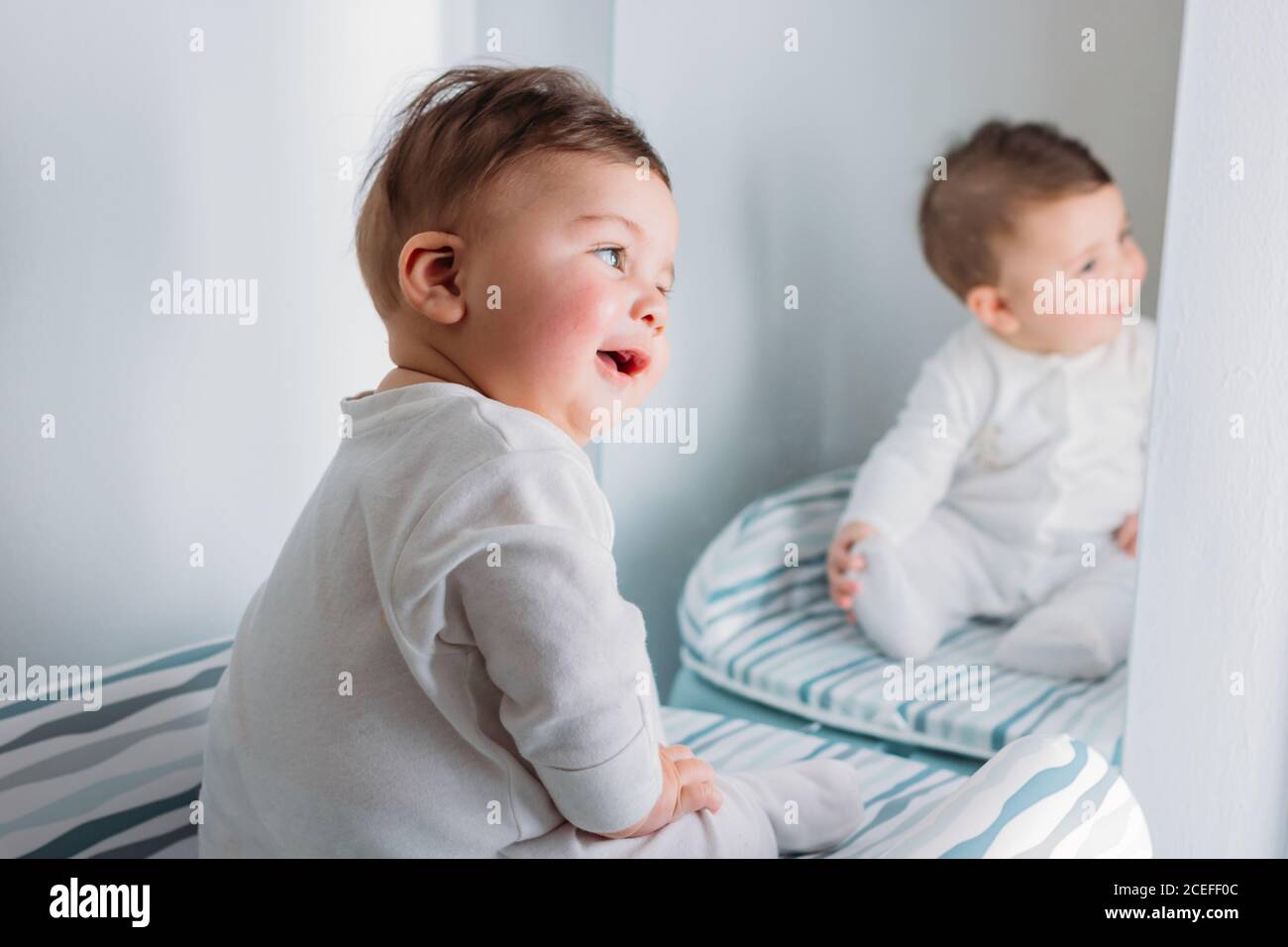 Bebe Doux Assis Sur Un Tapis Pres Du Miroir Et Regardant Son Propre Reflet Photo Stock Alamy
