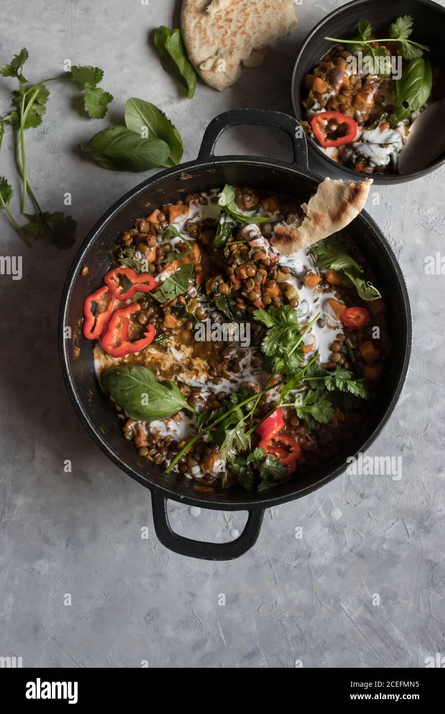 Bol près du pot avec ragoût de lentilles et patate douce curry Banque D'Images