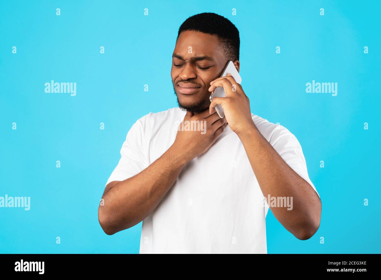 Homme malade ayant mal à la gorge appeler le docteur sur fond bleu Banque D'Images