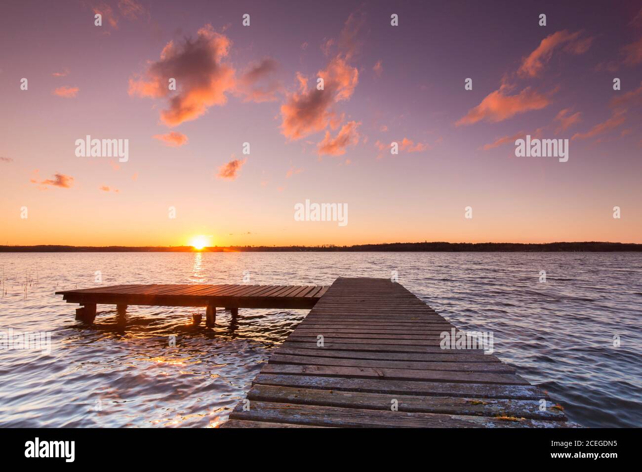 Jetée au coucher du soleil au lac Ratzeburg / Ratzeburger Voir au parc naturel des lacs de Lauenburg / Parc naturel Lauenburgische Seen, Schleswig-Holstein, Allemagne Banque D'Images