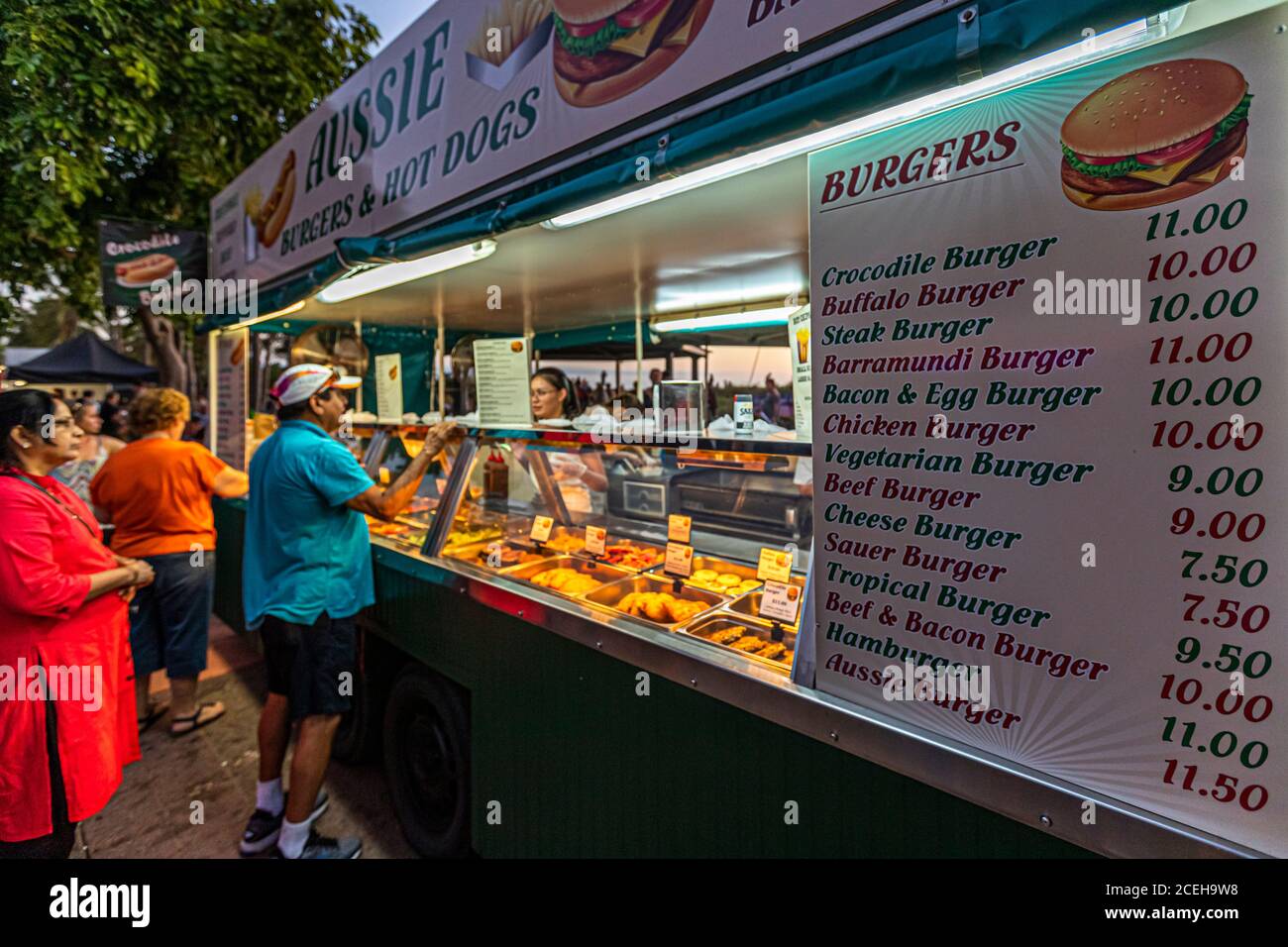 Un stand de nourriture étiqueté "Aussie Burgers & Hot Dogs" au Mindil Beach Sunset Market à Darwin, dans le Territoire du Nord, en Australie, propose des burgers au crocodile, au buffle et au barramundi parmi son menu. Banque D'Images