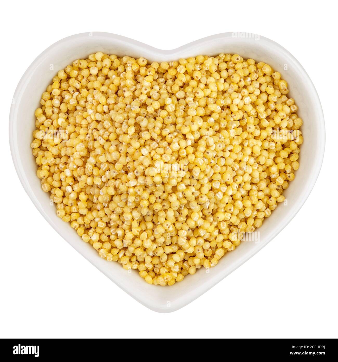 millet groats dans une assiette en forme de coeur Banque D'Images