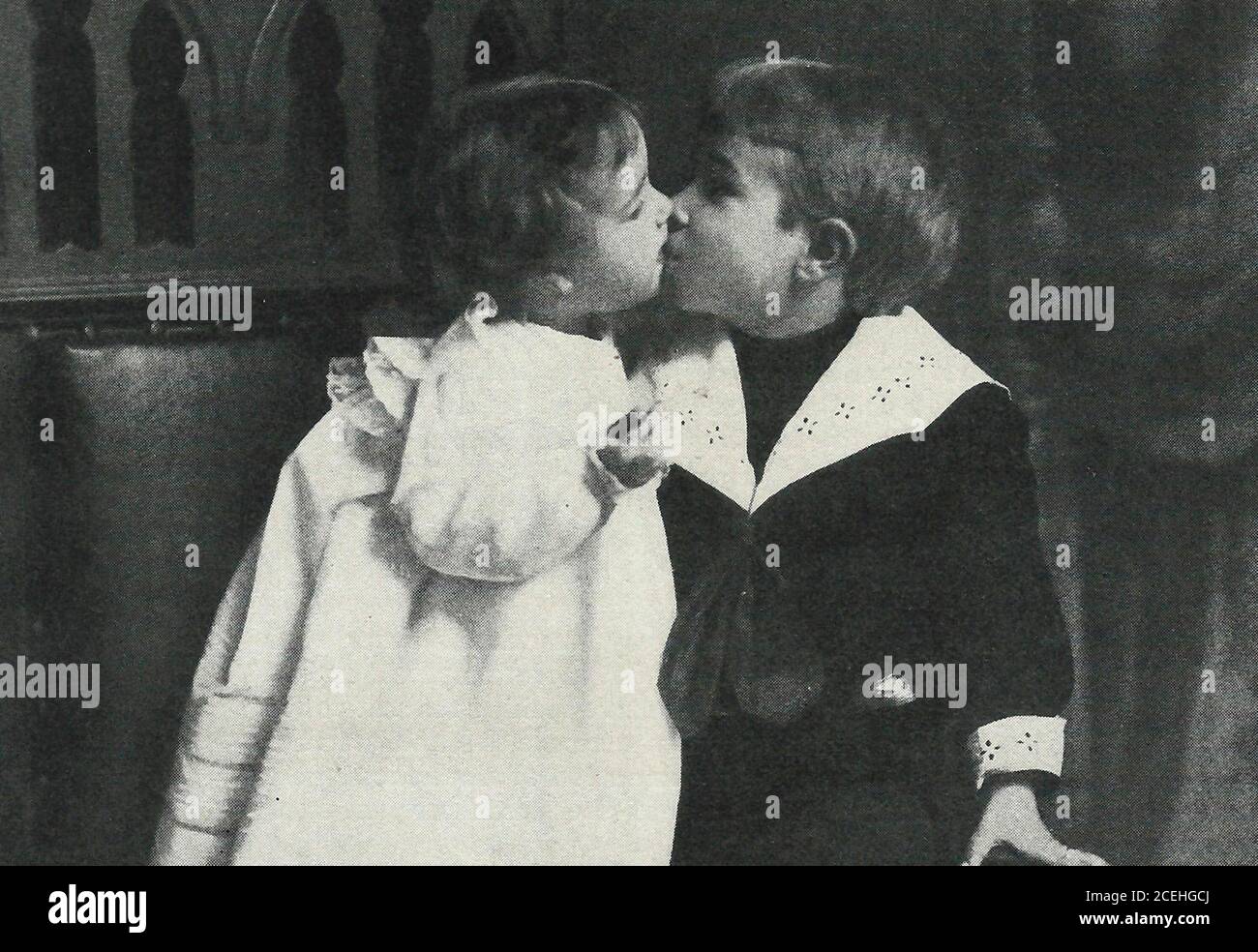 Un petit garçon et une fille embrassant, vers 1920 Banque D'Images