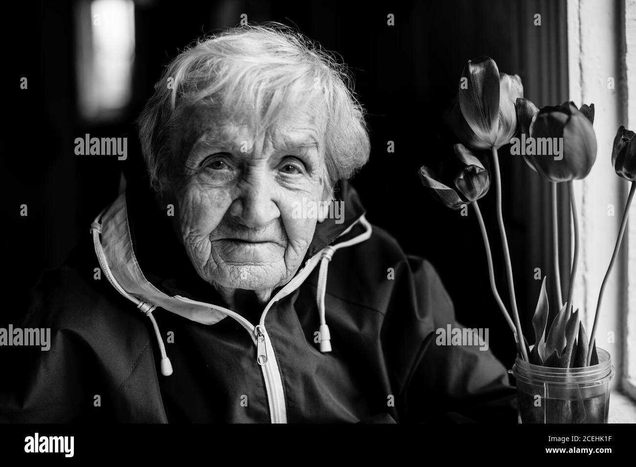 Portrait d'une vieille femme posant pour l'appareil photo. Photo en noir et blanc. Banque D'Images