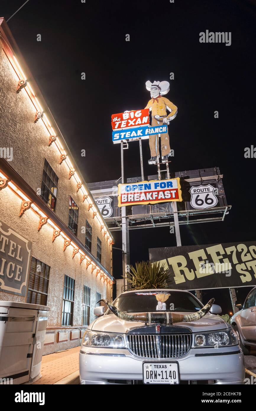 Tamarillo USA - septembre 12 2015 ; voiture avec cornes garée à l'extérieur du Big Texan Steak Ranch, la nuit sous les célèbres panneaux Texas, USA Banque D'Images