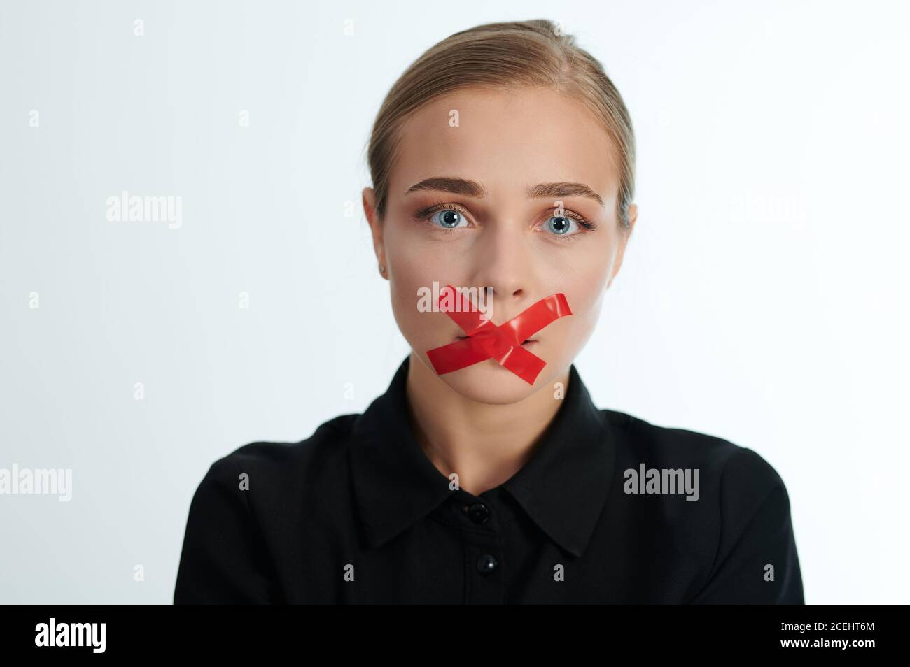 Portrait de la femme pleurant avec une bouche fermée sur fond blanc de studio Banque D'Images