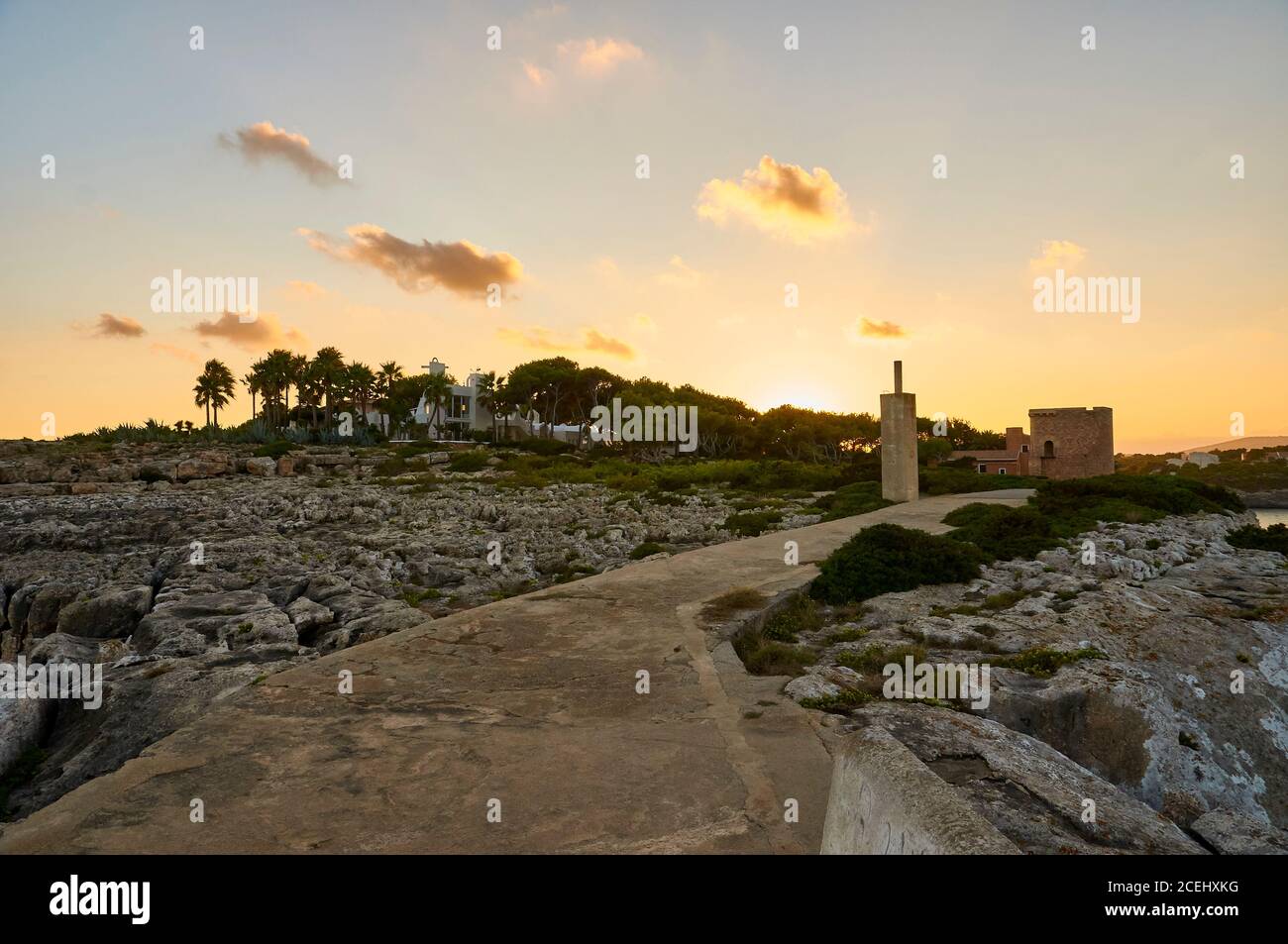 Ancienne tour, promenade et villa de luxe près du cap Punta de sa Torre au coucher du soleil (Santanyí, Majorque, Iles Baléares, Mer méditerranée, Espagne) Banque D'Images