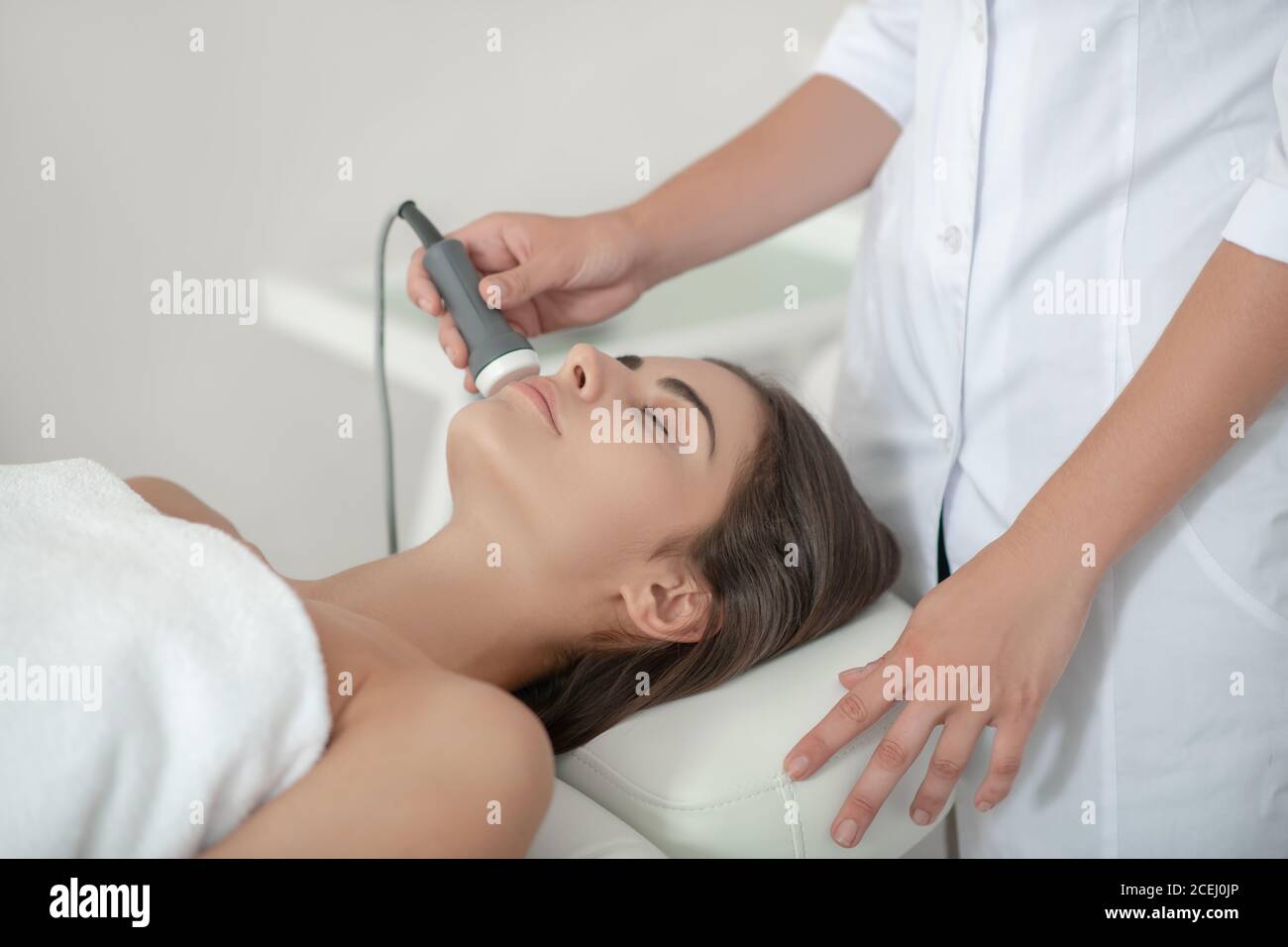 Un cosmétologue travaillant avec un client dans un salon de beauté Banque D'Images