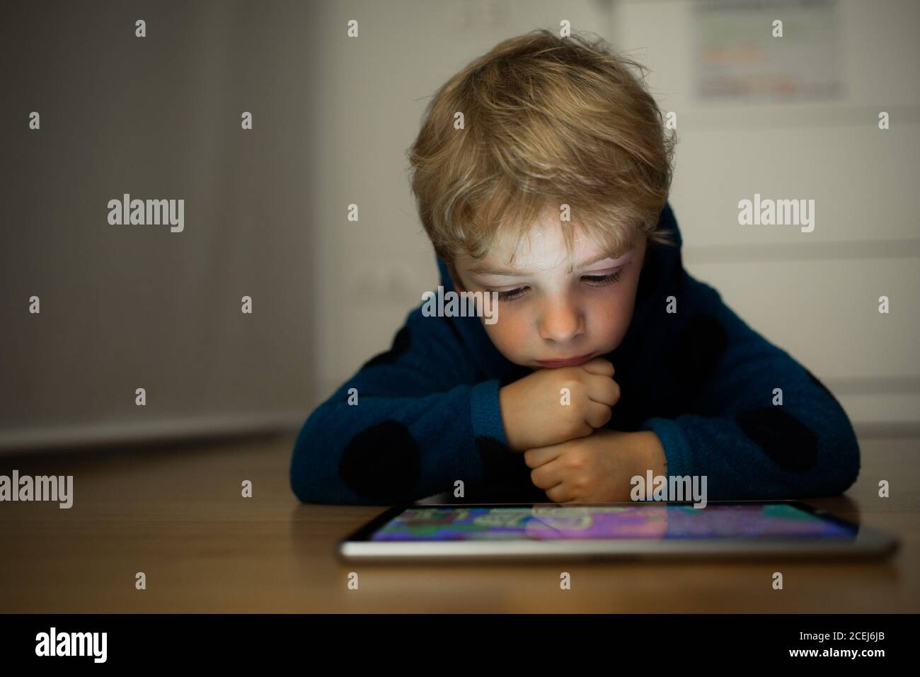 Un garçon caucasien regarde des dessins animés dans une tablette Banque D'Images