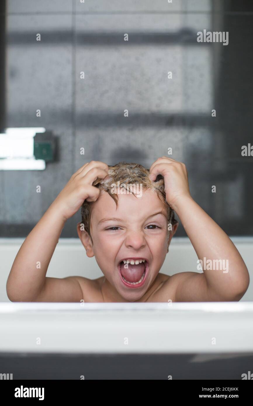 Un garçon caucasien jouant dans la douche Banque D'Images