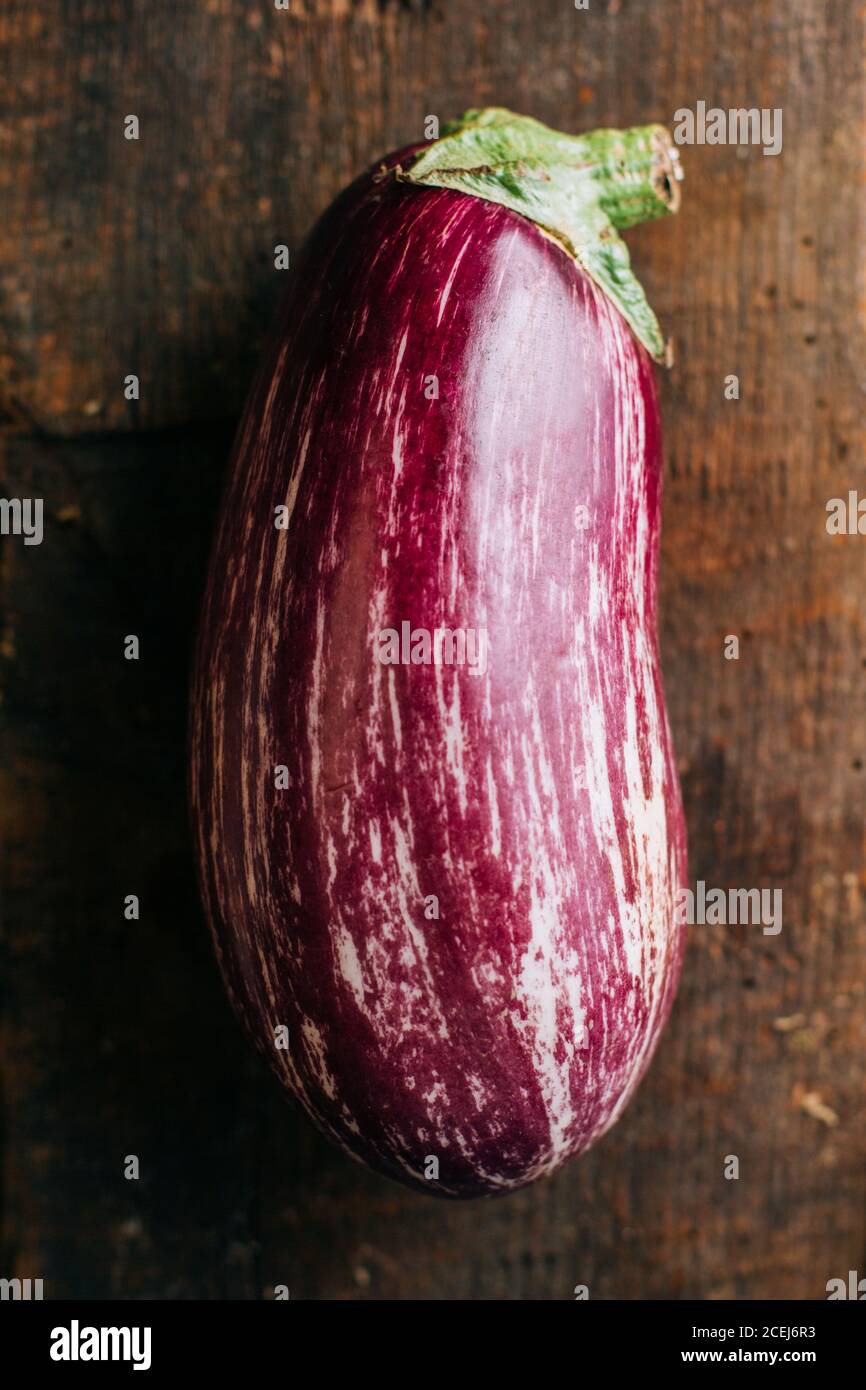 Aubergine graffiti sur table en bois et fond sombre Banque D'Images