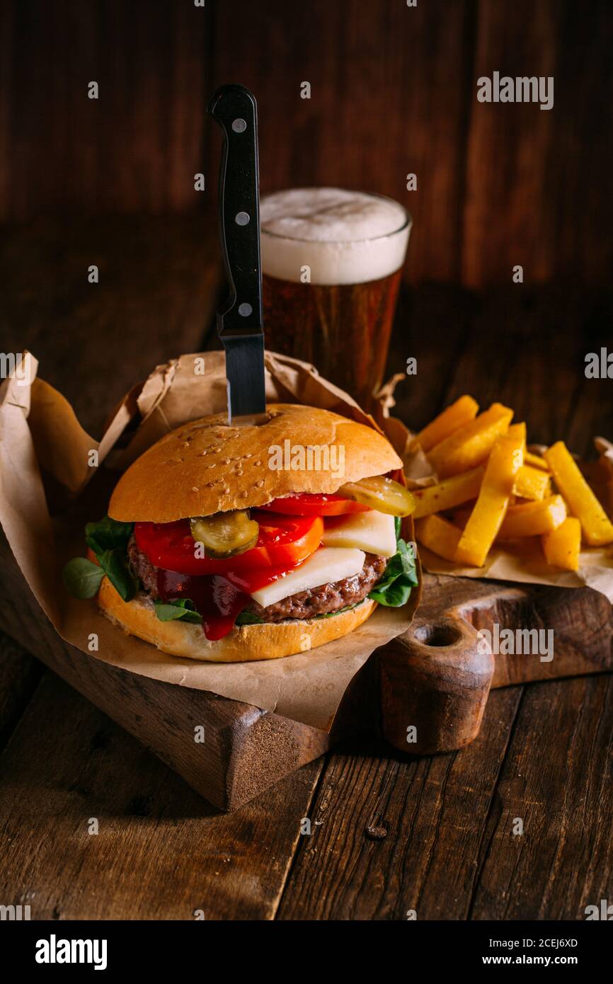 Délicieux hamburger gastronomique sur fond de bois sombre Banque D'Images