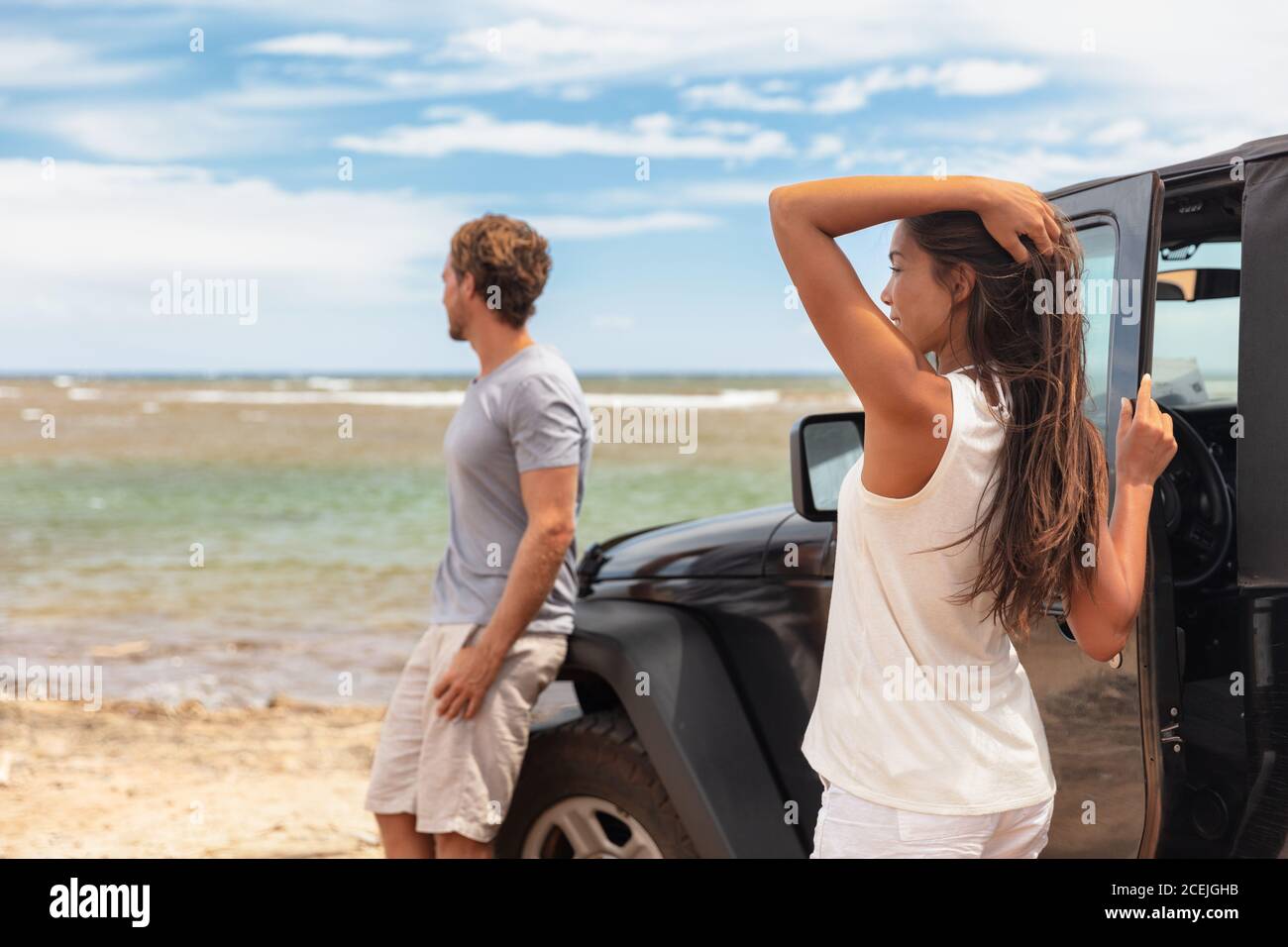 Couple en voyage sur route vacances à Hawaï en voiture sur la plage. Jeunes touristes appréciant les vacances Banque D'Images
