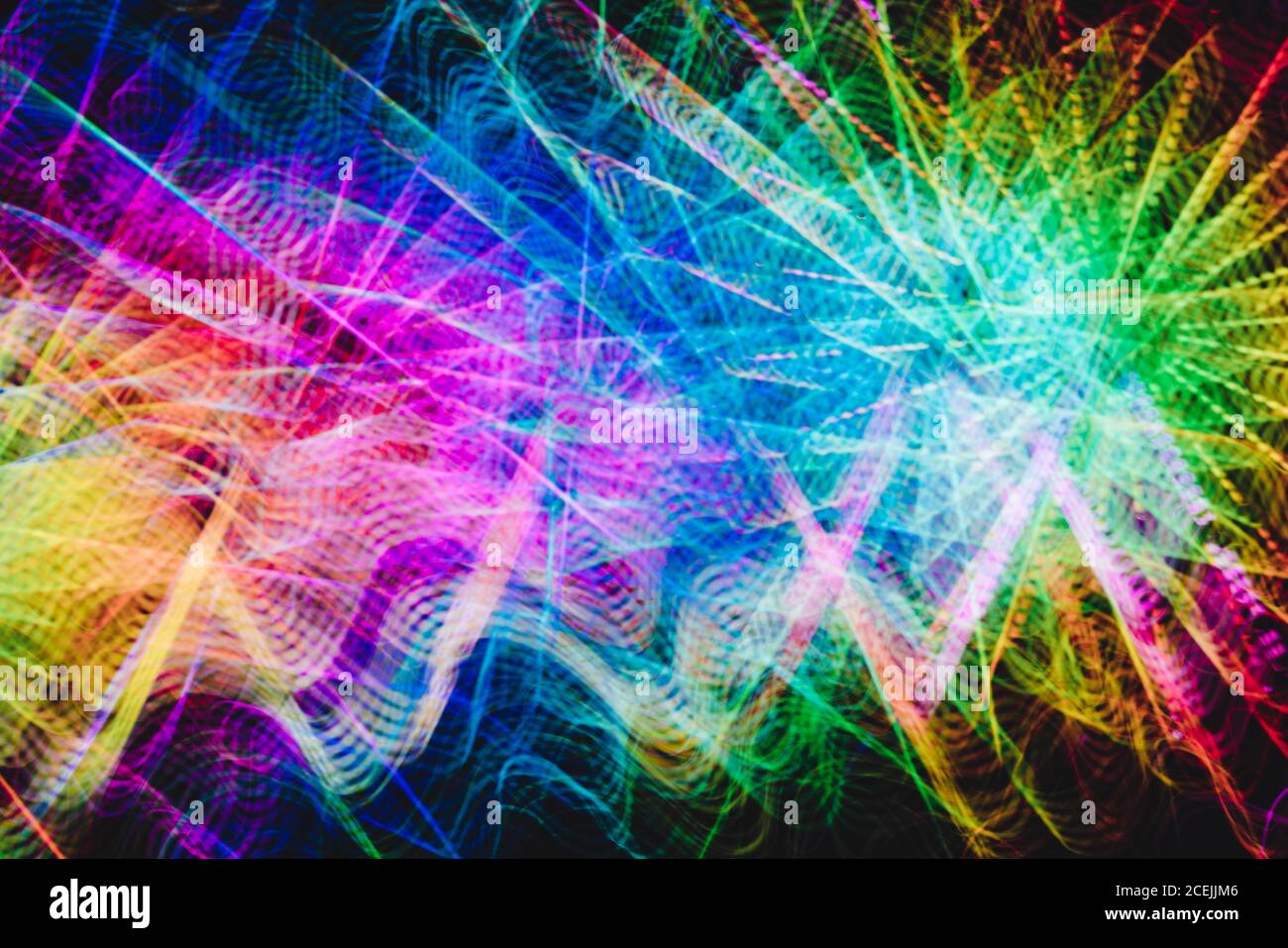 Des pistes courbes de lumière multicolore lumineuse sur fond noir Photo  Stock - Alamy