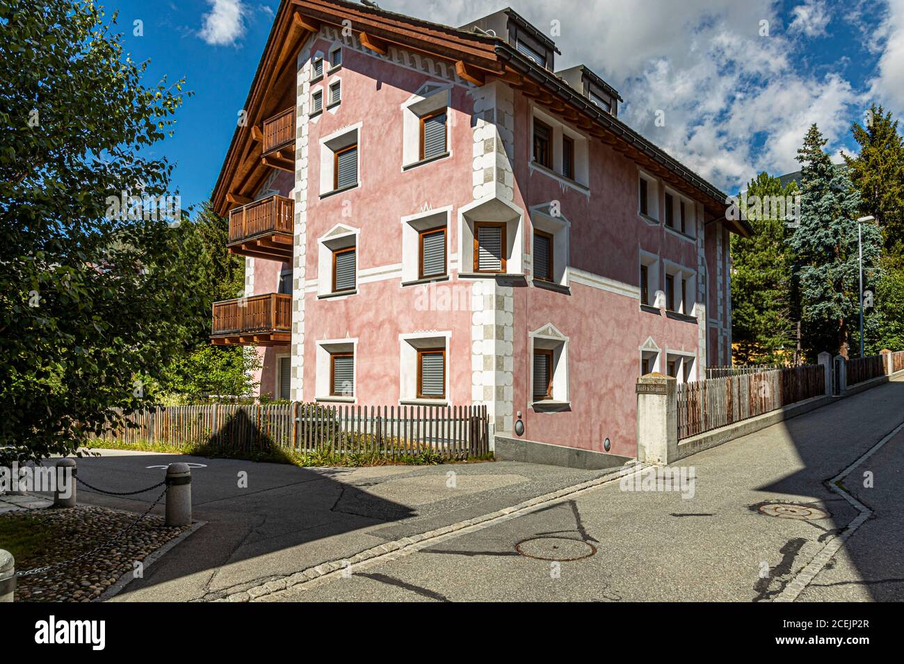Une maison rose de style Engadin à Celerina, en Suisse, présente également l’ornementation typique en sgraffito autour de ses fenêtres – la technique traditionnelle de plâtre rayé de la région. Banque D'Images