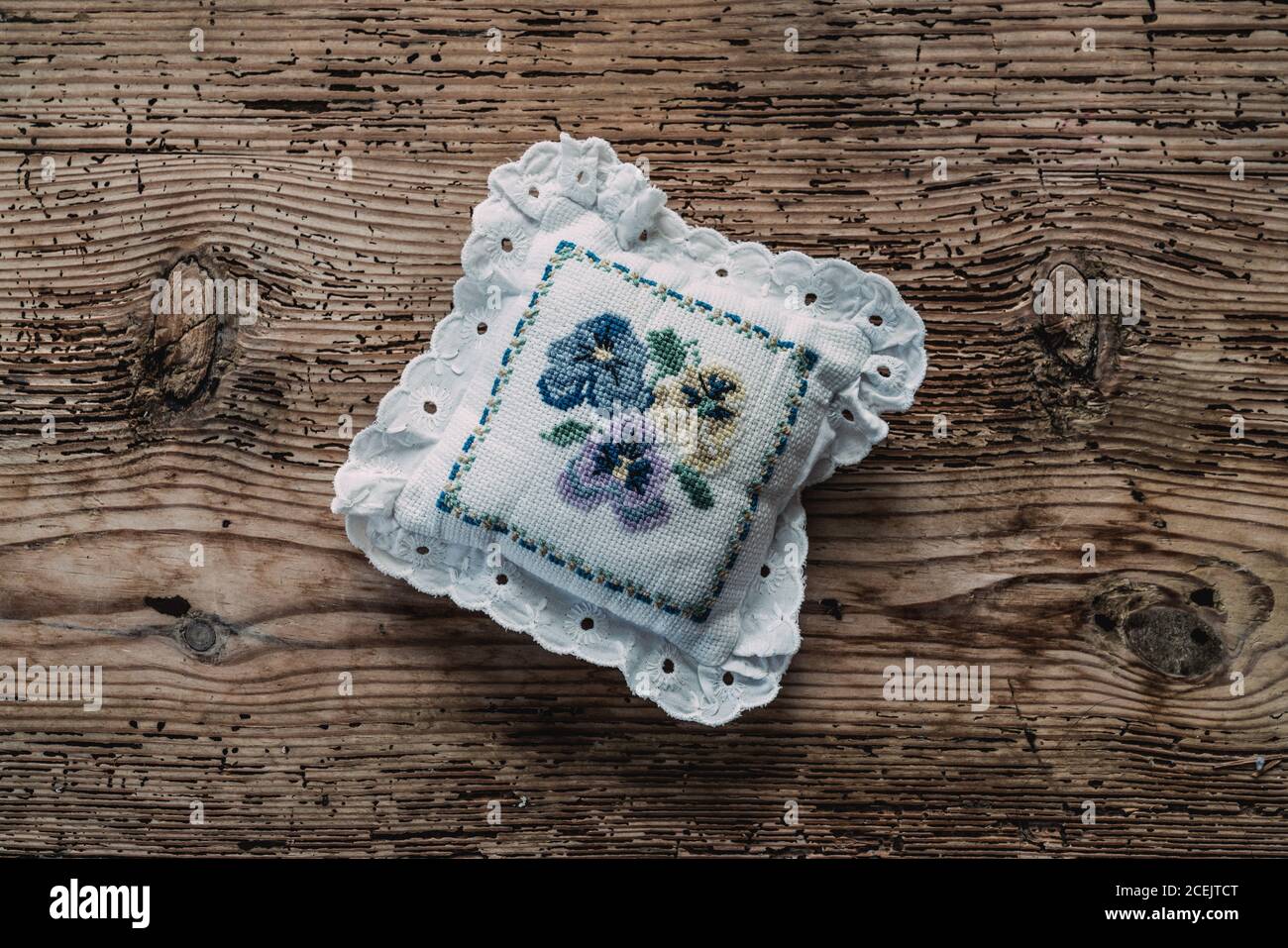 Petit coussin de pin vintage†avec peinture de fleur placé sur le bureau en bois Banque D'Images