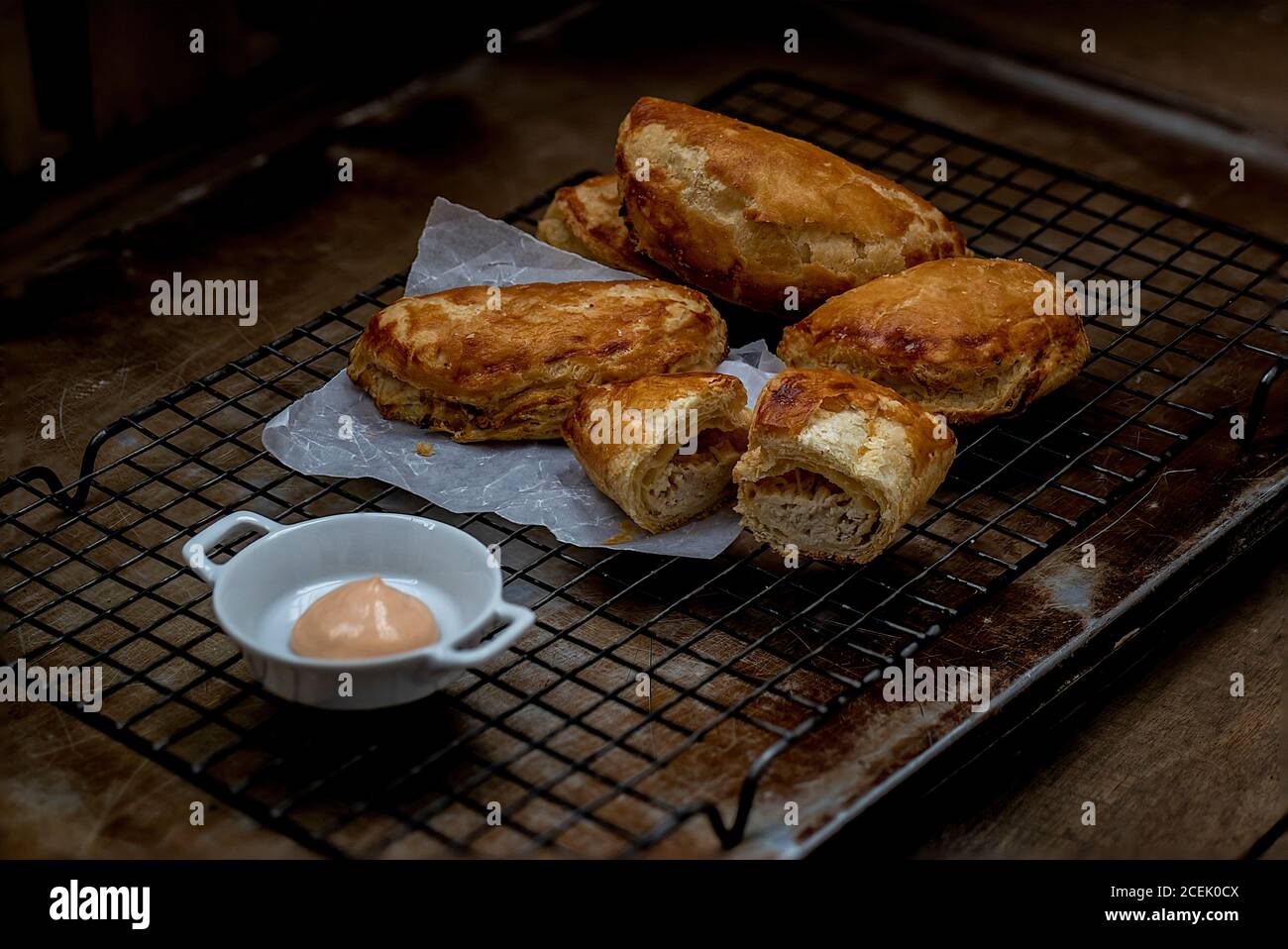 Vue du dessus de la pâte feuilletée placée sur la grille de cuisson et un bol de sauce placé près de Banque D'Images