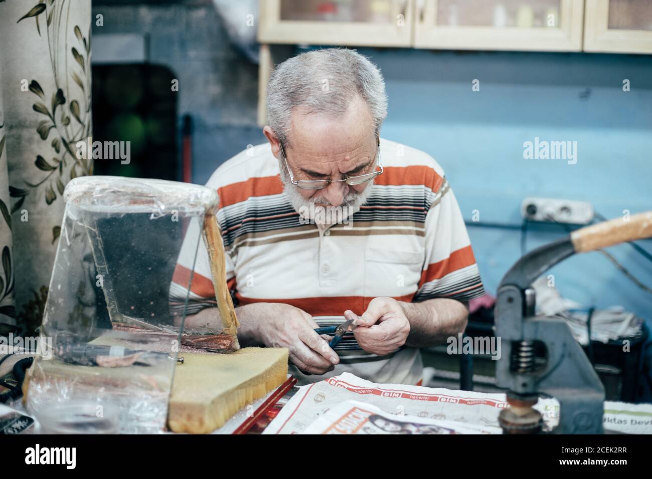 Istanbul, Turquie - août 17 2018 : maître adulte assis sur le lieu de travail dans la boutique et la plaque de gravure Banque D'Images