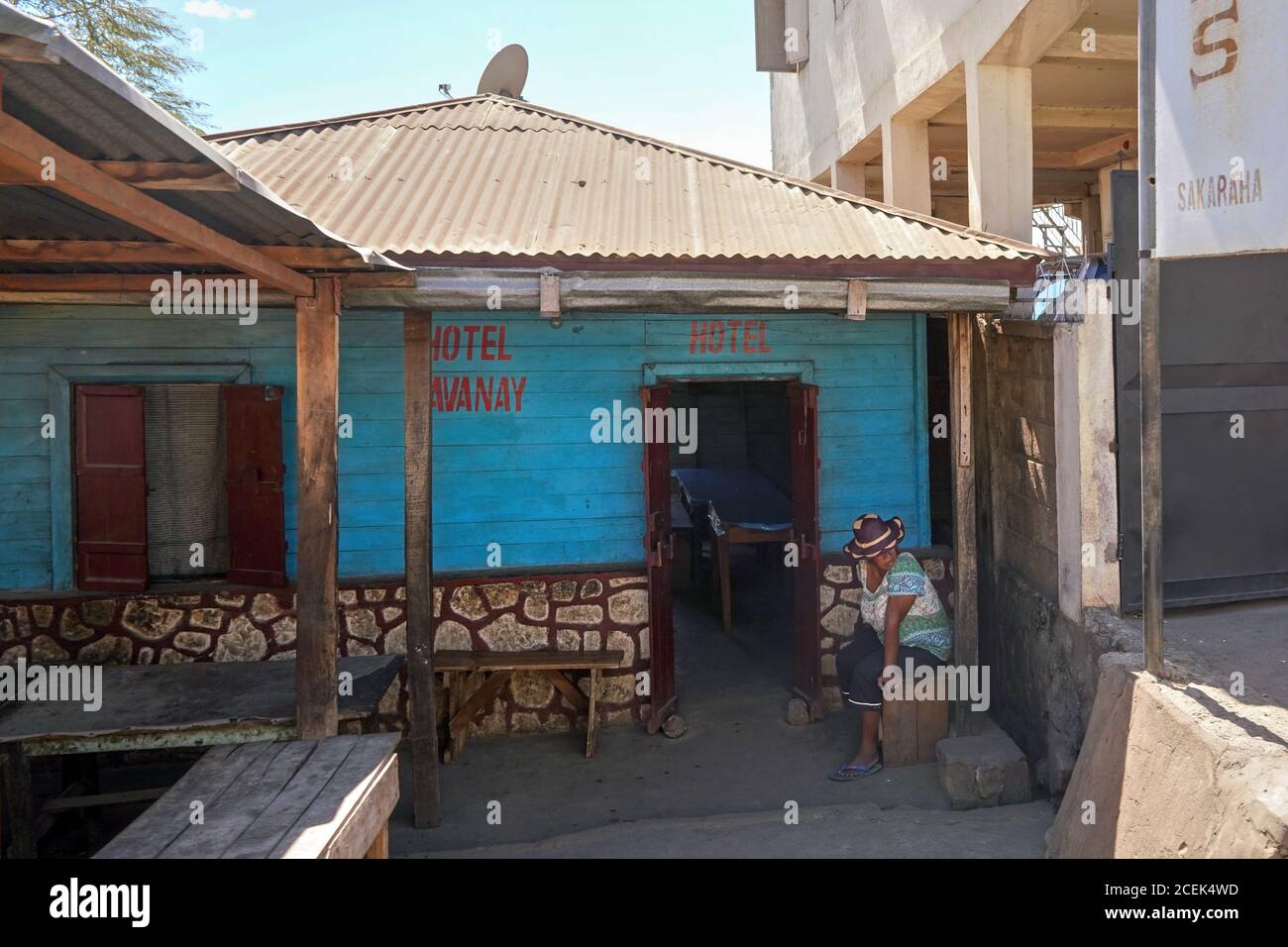 Sakaraha, Madagascar - 05 mai 2019: Anonyme Malgache femme en chapeau assis devant sa maison annoncé comme HÔTEL. Beaucoup de gens du coin offrent un hébergement bon marché Banque D'Images