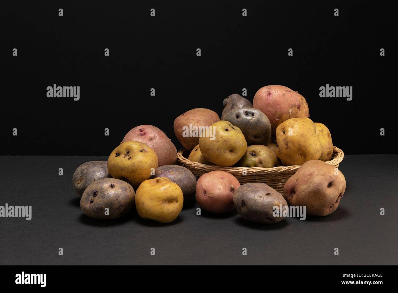 Durée de vie des légumes à faible teneur en clé. Différents types de légumes en studio. Trois sortes de pommes de terre dans un panier. Banque D'Images