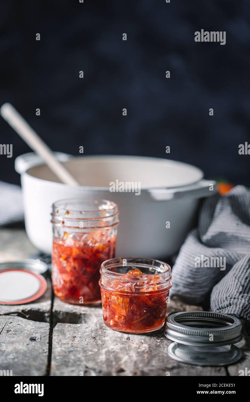 Pots remplis de confiture d'oranges rouges sur une table rustique en bois. Banque D'Images Pots remplis de confiture d'oranges rouges sur une table rustique en bois. Banque D'Images