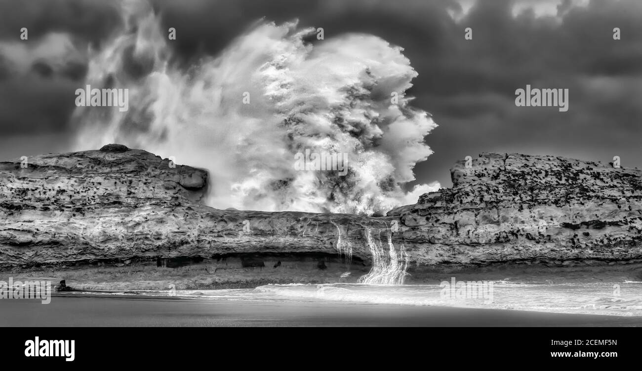 Des vagues cycloniques massives qui démontrent la puissance de l'océan s'écraser le récif côtier Banque D'Images