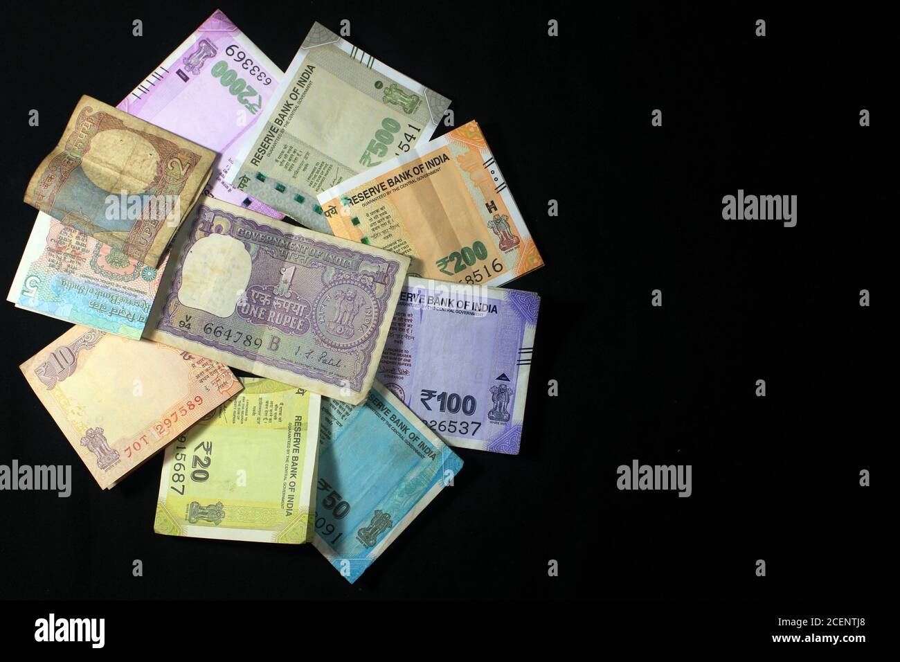 Aujourd’hui et dans l’ancienne monnaie indienne. billets et pièces de 50, 100, 200, 500, 2000 roupies. Monnaie indienne isolée sur fond noir. Banque D'Images
