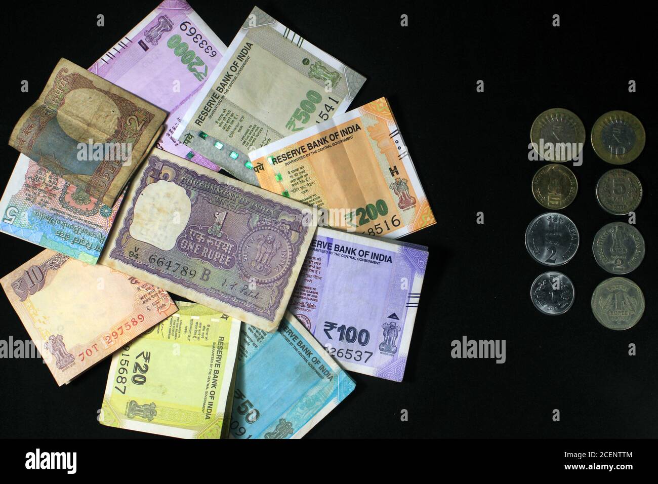 Aujourd’hui et dans l’ancienne monnaie indienne. billets et pièces de 50, 100, 200, 500 roupies. Monnaie indienne isolée sur fond noir. Banque D'Images