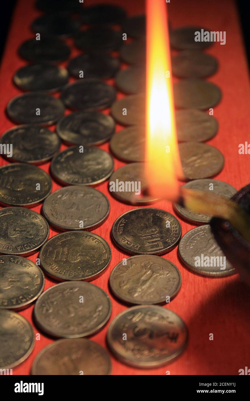 Pièces de monnaie en roupie indienne avec bougie. Pile de 1, 2, 5, 10 monnaie métallique de roupie indienne isolée sur fond rouge. Financier, économie Banque D'Images