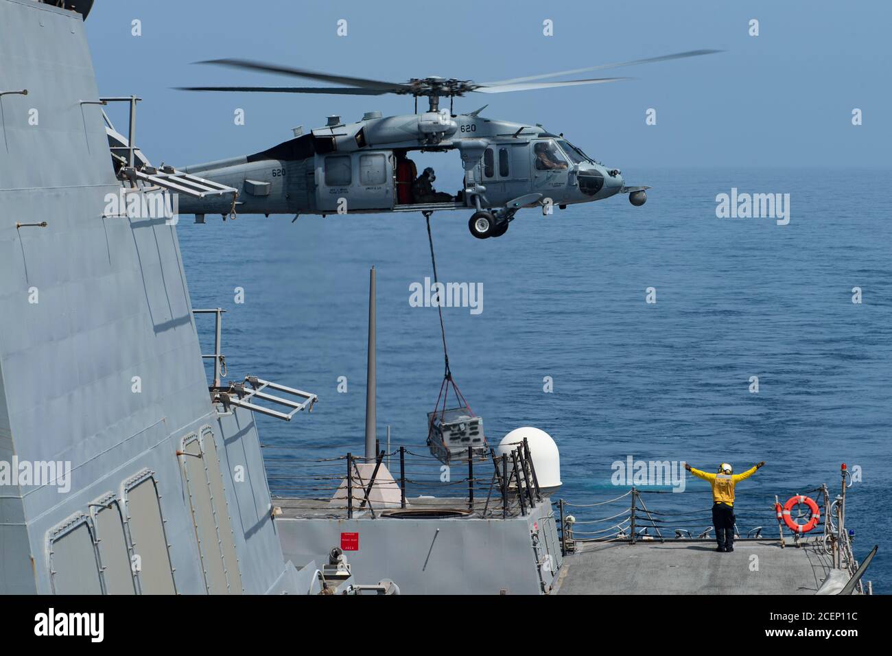 200829-N-NC885-1024 MER D'ARABIE (AOÛT 29, 2020) le compagnon de Boatswain de 2e classe Kelvin Tyler, de Philadelphie, guide un hélicoptère MH-60S Sea Hawk, des 'Indienss' de l'escadron de combat de la mer (HSC) 6 pour déposer des provisions sur le pont de vol du destroyer de missile guidé de classe Arleigh Burke USS Sterett (DDG 104), lors d'un réapprovisionnement en mer. Sterett fait partie du Nimitz Carrier Strike Group et est déployé dans la zone d'opérations de la 5e flotte des États-Unis pour assurer la stabilité et la sécurité maritimes dans la région centrale, reliant la Méditerranée et le Pacifique à travers l'Inde occidentale Banque D'Images