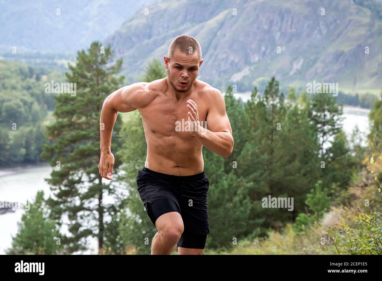 L'athlète sportif s'élève en amont dans la montagne, la rivière, les montagnes et la forêt. Course de sprint. Effet de mouvement et de course rapide, flou Banque D'Images