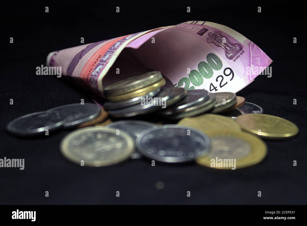 Nouvelle monnaie indienne. note de 2000 roupies avec pièces. Monnaie indienne isolée sur fond noir. Banque D'Images