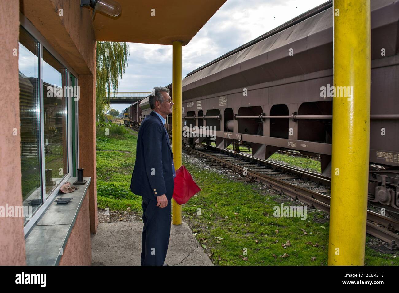 Zrenjanin, Serbie, 16 novembre 2015. Entrée d'un train de marchandises dans la gare. L'agent de chemin de fer surveille chaque voiture de fret avec vigilance Banque D'Images