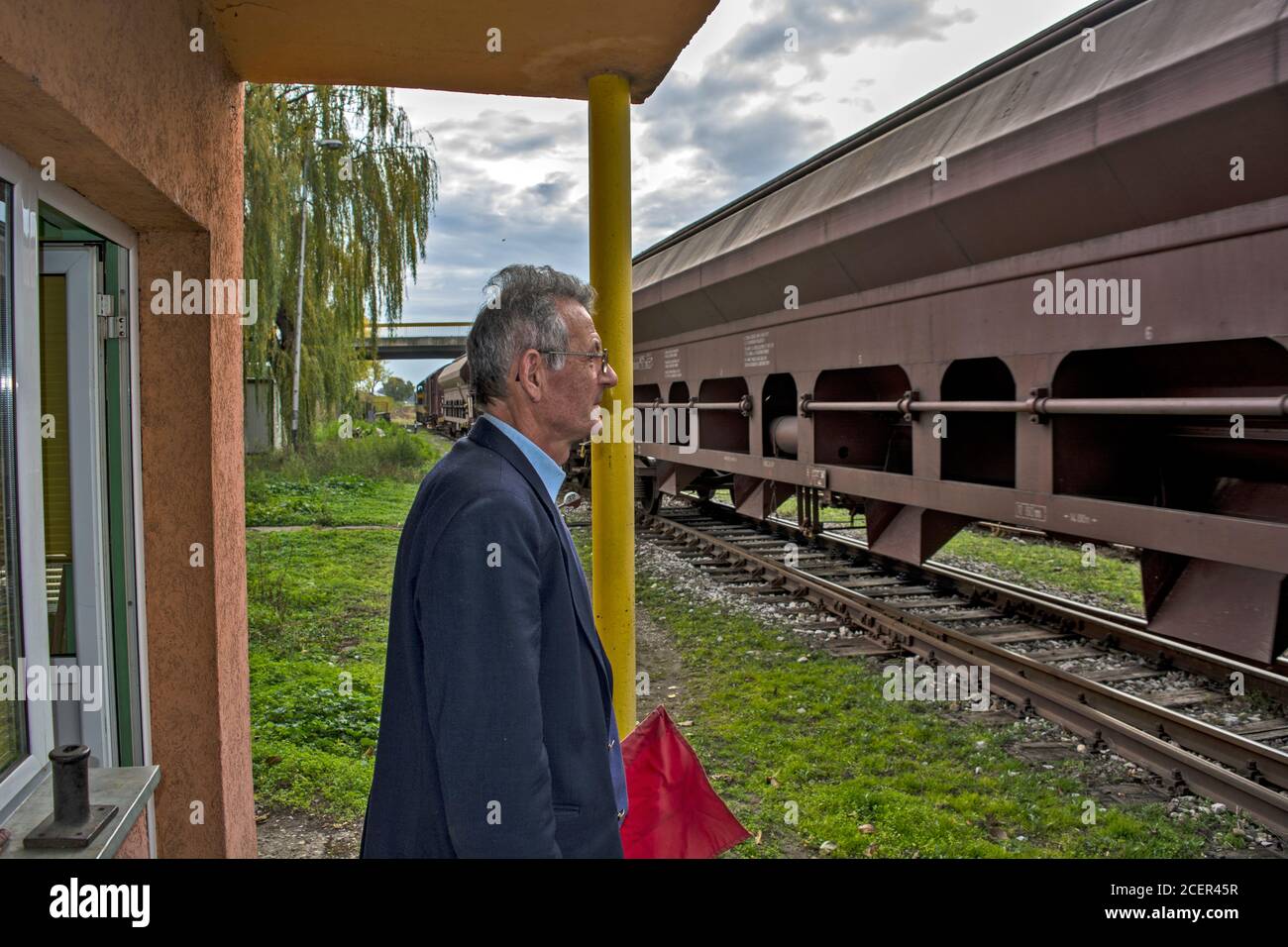 Zrenjanin, Serbie, 16 novembre 2015. Entrée d'un train de marchandises dans la gare. L'agent de chemin de fer surveille chaque voiture de fret avec vigilance Banque D'Images
