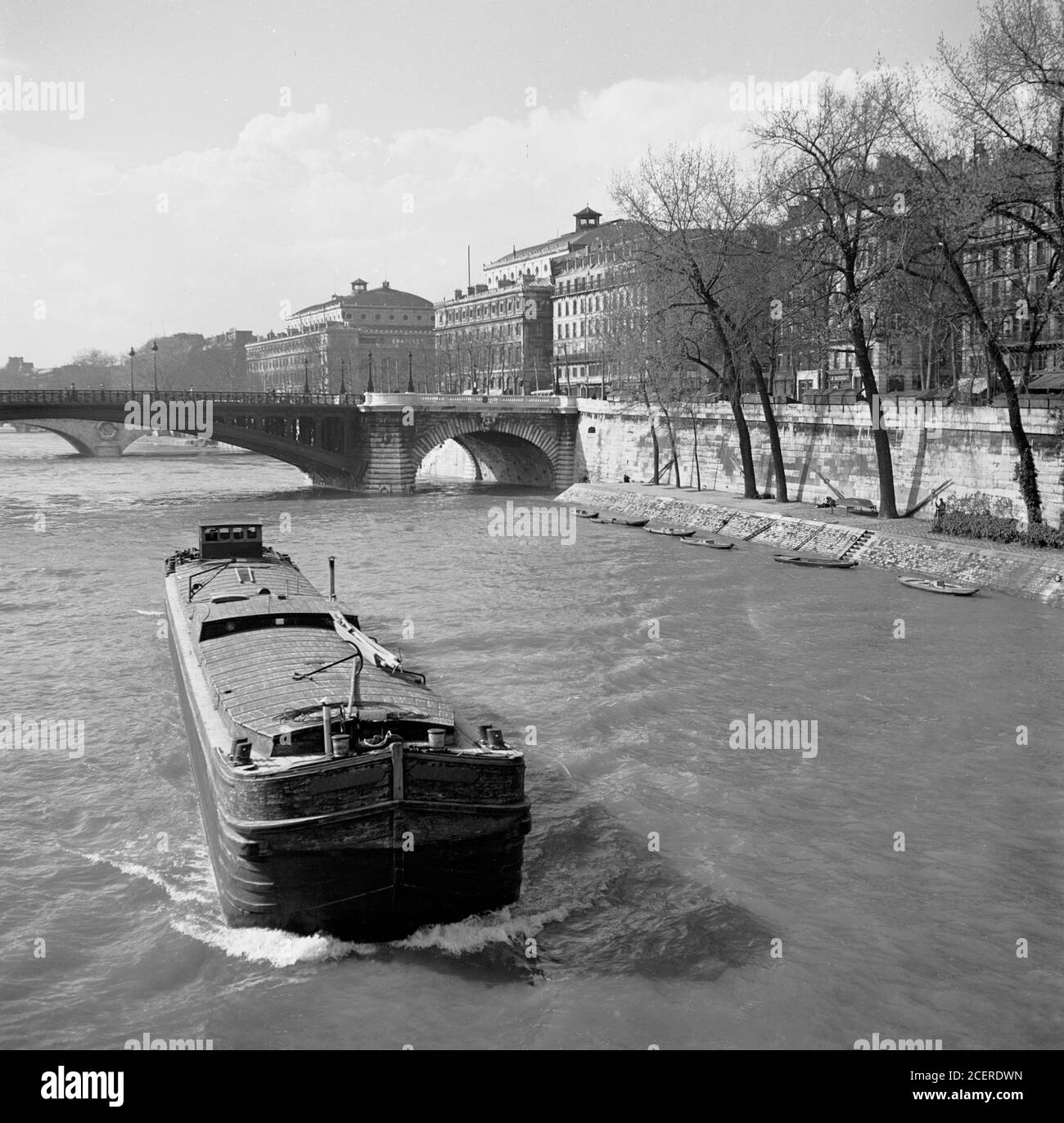1950s, historique, une longue barge de l'époque qui descend la Seine, Paris, France. Banque D'Images