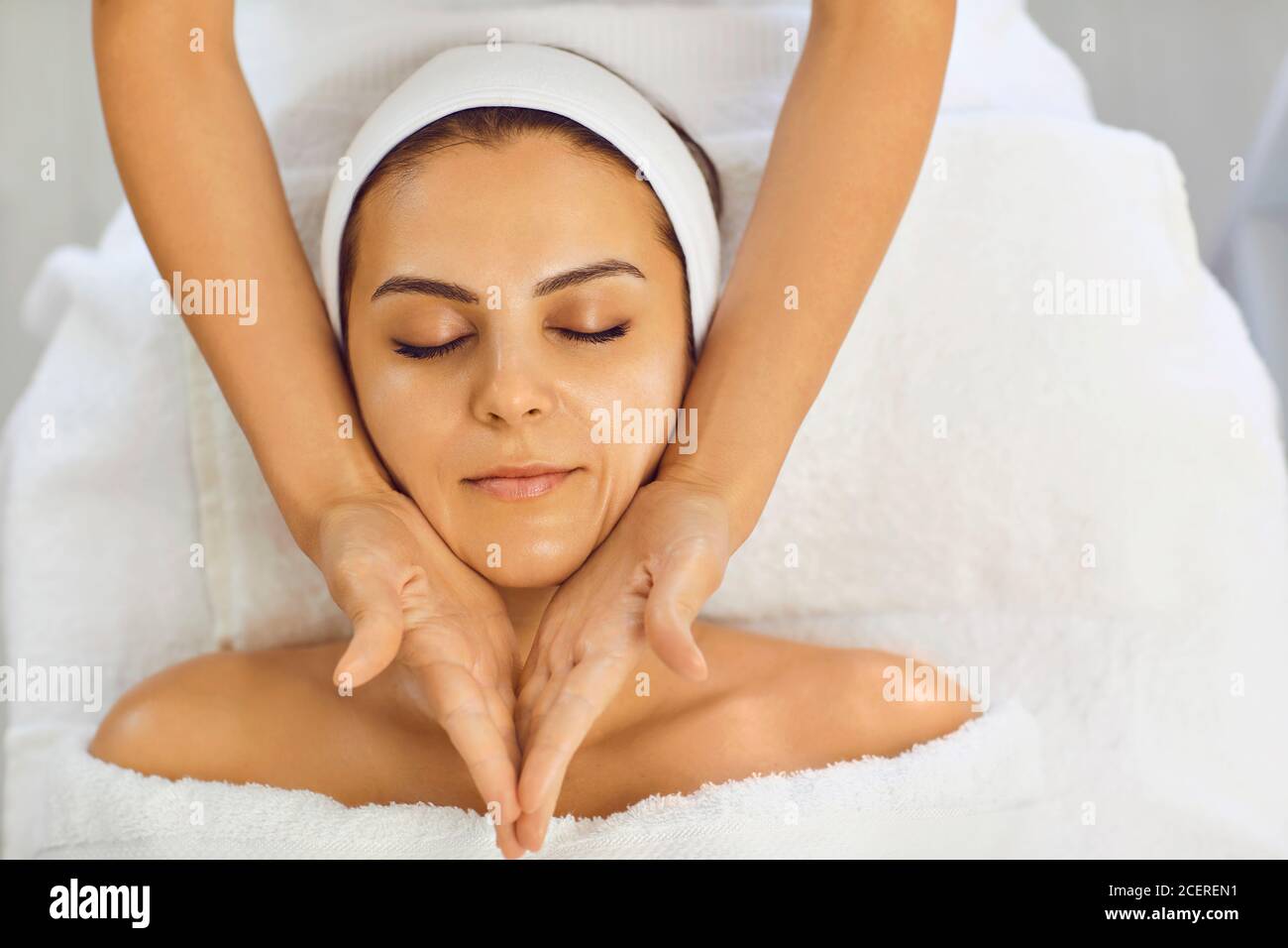 Jeune femme recevant un massage du visage au salon kosmetalogicheskom. Soin du visage. Banque D'Images