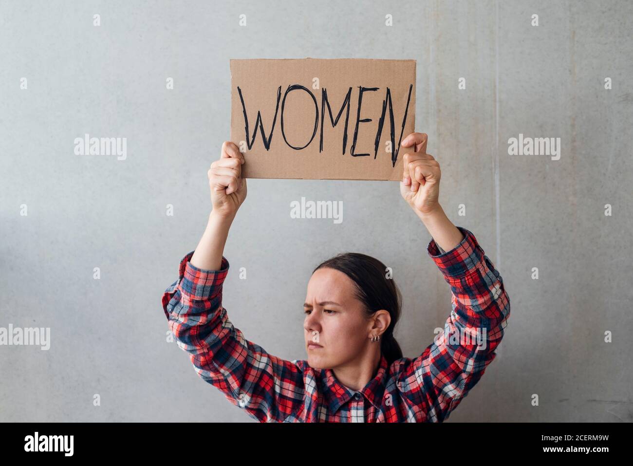 Femme militante avec une affiche près d'un mur en béton dans la rue. Pour les droits des femmes Banque D'Images