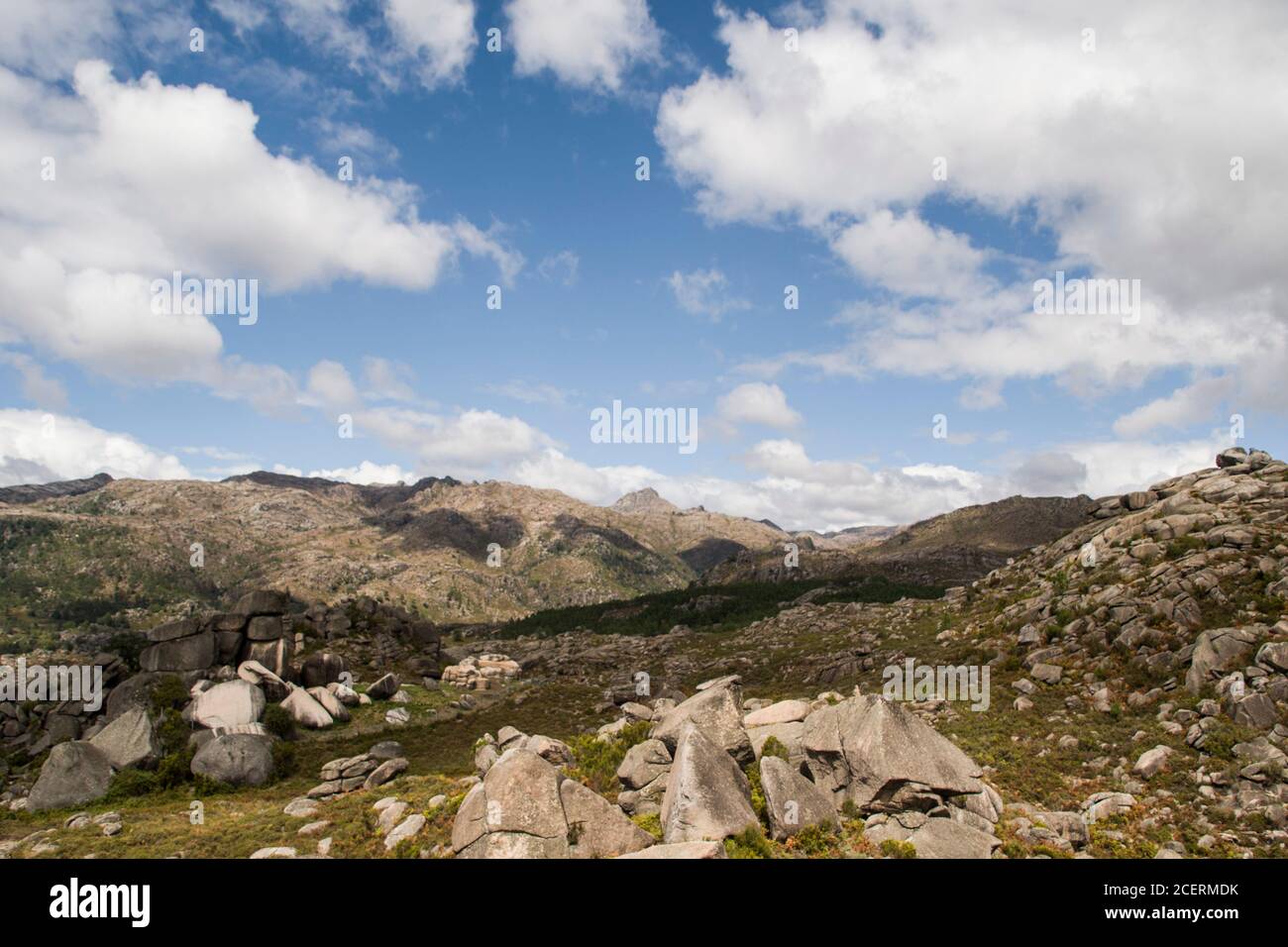 Paysage de montagne vert et rocailleux sous un ciel bleu avec nuages blancs et nuances de nuages sur la vue Banque D'Images