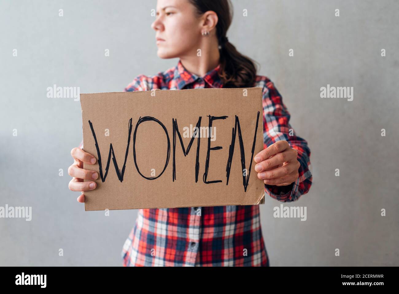 Femme militante avec une affiche près d'un mur en béton dans la rue. Pour les droits des femmes Banque D'Images