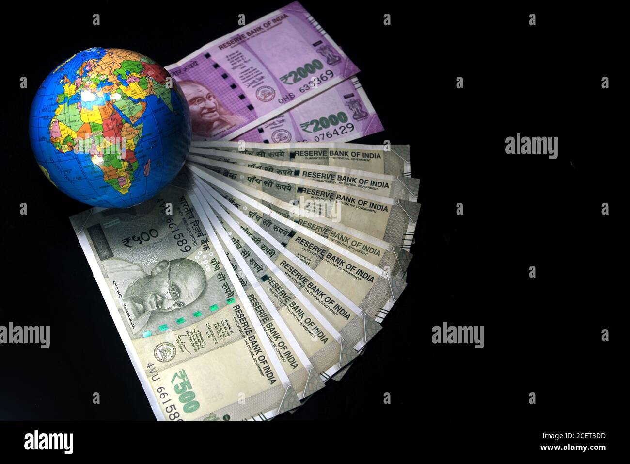 Nouvelle monnaie indienne. 500, et 2000 roupies notes avec globe. Monnaie indienne isolée sur fond noir. Banque D'Images
