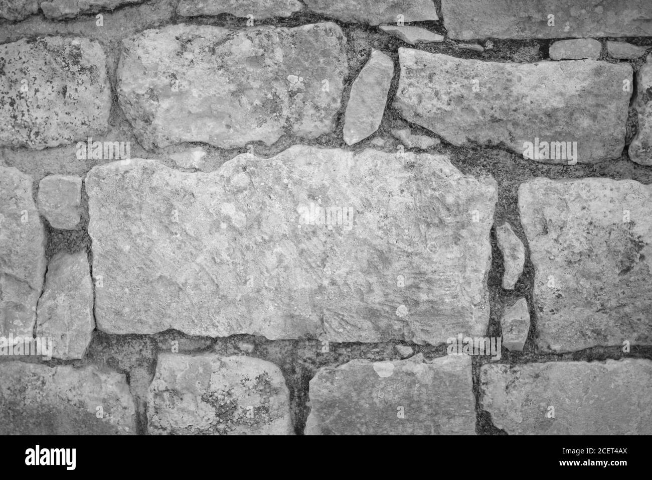 Partie ancienne d'un mur de différentes pierres en noir et blanc Banque D'Images