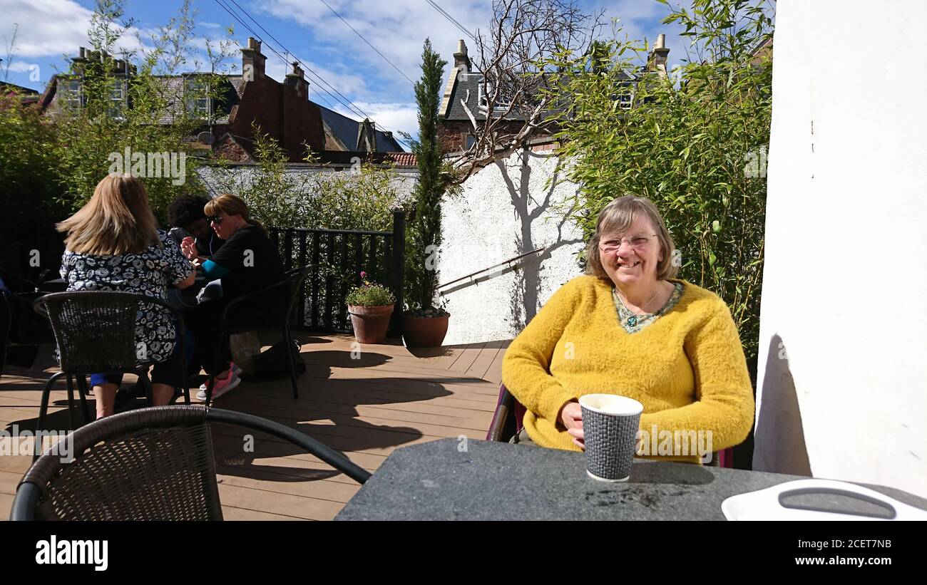 Femme assise dans un café extérieur à North Berwick Banque D'Images