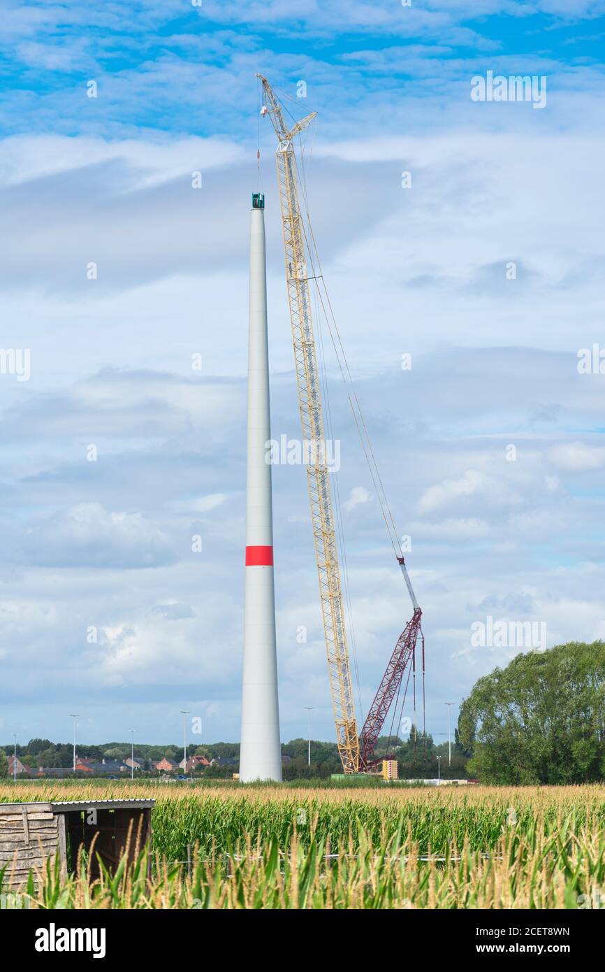 Sint Gillis Waas, Belgique, 24 août 2020, Construction d'une éolienne avec une grande grue à côté et un ciel bleu et des nuages blancs comme un backgroun Banque D'Images