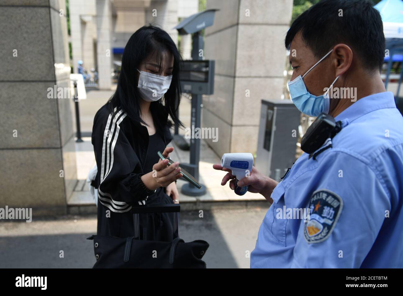 Haikou, Chine. 02 septembre 2020. Un agent de sécurité vérifie les diplômes des élèves.les élèves de l'Université Hainan dans la province de Hainan portent des masques pour retourner à l'école, à l'heure actuelle, bien qu'il y ait très peu de cas de COVID-19, les élèves doivent être vérifiés pour leur santé, montrer leurs dossiers de voyage et leurs cartes d'identité, pour entrer dans l'école. Les universités chinoises effectuent toujours un examen d'entrée strict pour éviter la propagation du virus due au flux d'étudiants. Crédit : SOPA Images Limited/Alamy Live News Banque D'Images