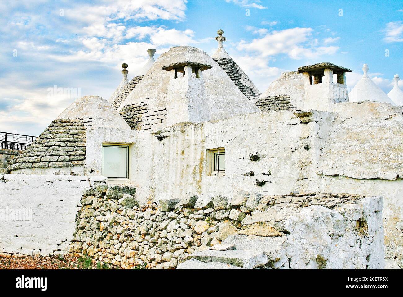 Groupe de belles maisons blanches Trulli, ancienne hutte traditionnelle en pierre sèche des Pouilles avec un toit conique dans la vallée d'Itria, Puglia, Italie Banque D'Images